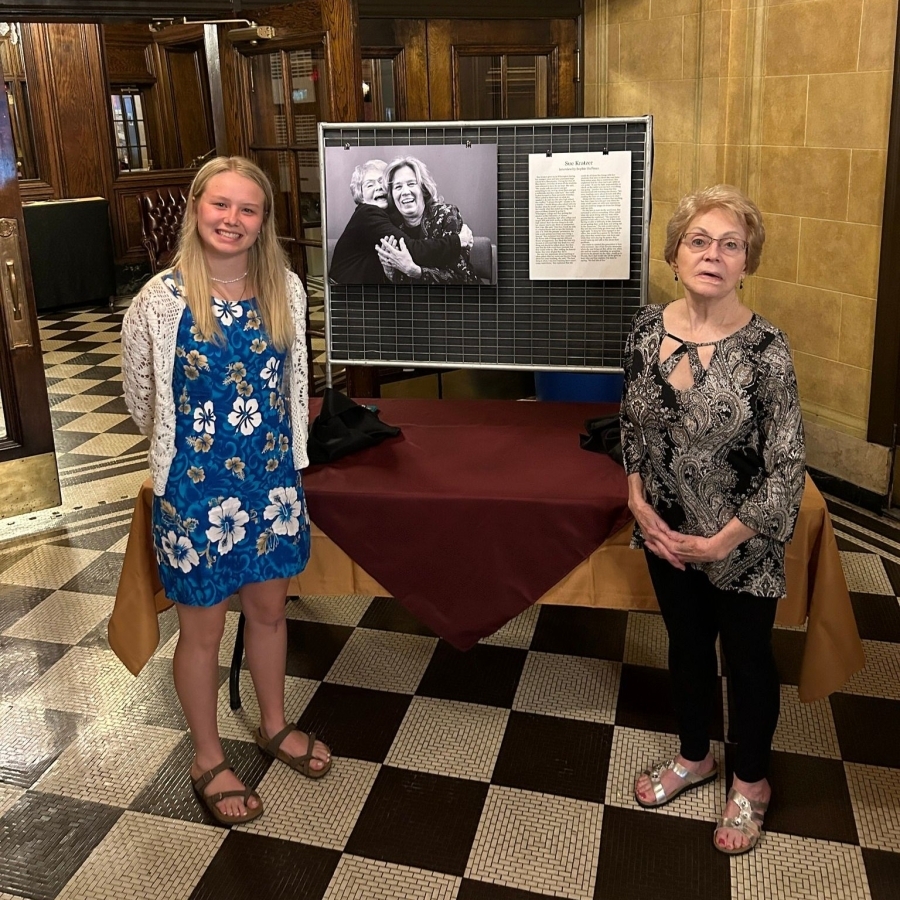 a student standing next to a woman next to a presentation board